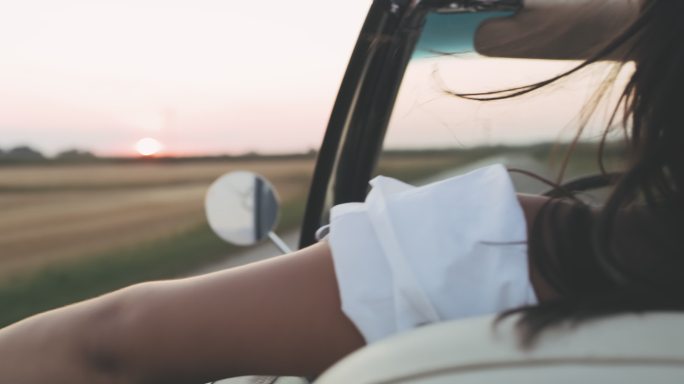 无忧无虑的年轻女子驾驶敞篷车行驶在乡村
