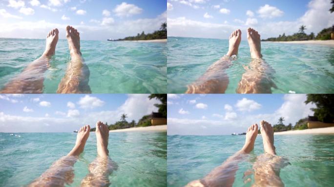 女人在海洋中放松，双脚漂浮在水中