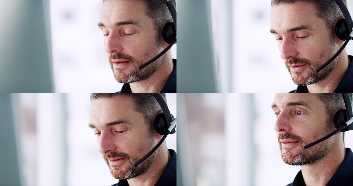 男性呼叫中心代理在办公室使用耳机