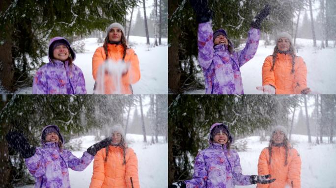 在玩雪的姐妹雪地女孩玩耍雪花抛向高空开心