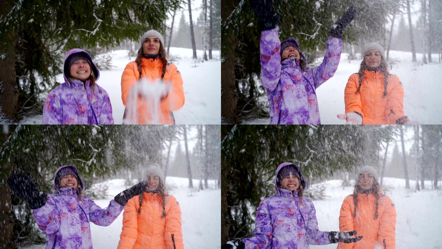 在玩雪的姐妹雪地女孩玩耍雪花抛向高空开心