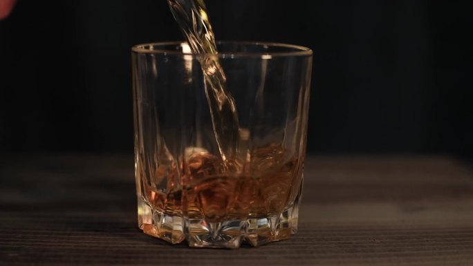 将威士忌倒入玻璃杯的超慢镜头