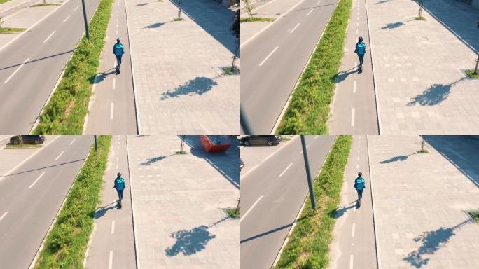 一名信使骑着滑板车在自行车道上