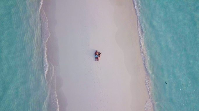 一对年轻的成年夫妇一起躺在沙滩