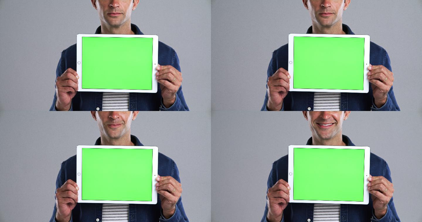 男子拿着一个绿色屏幕的数字平板