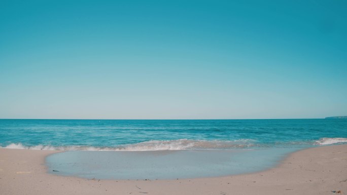 青绿色海浪冲刷着干净的沙滩