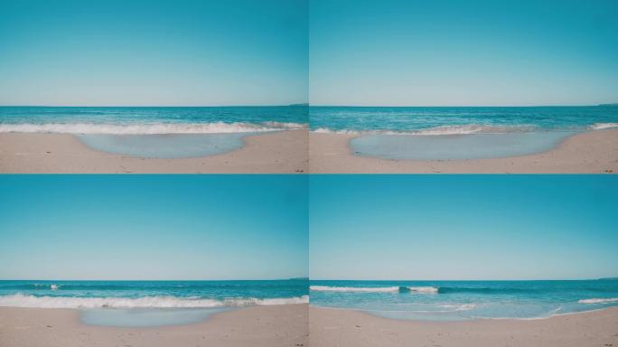 青绿色海浪冲刷着干净的沙滩