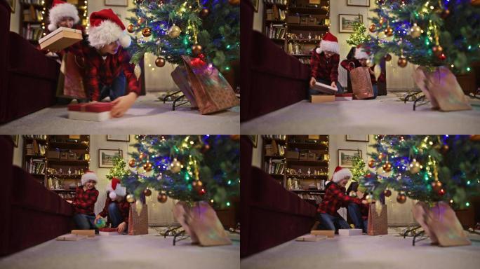 淘气的小男孩从圣诞树下偷礼物