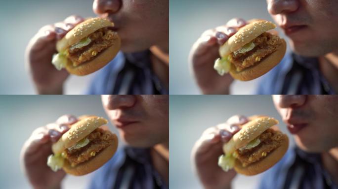 特写镜头中的男人正在吃汉堡包。