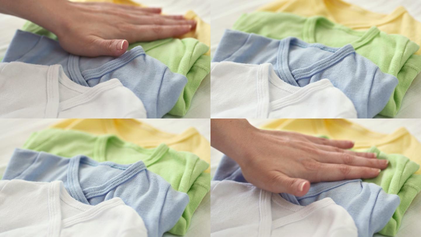 抚摸婴儿衣服的手纯棉衣物特写