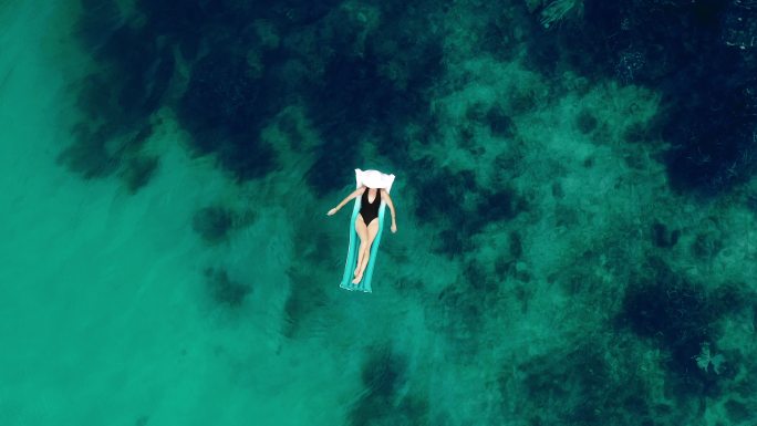 年轻女子漂浮在海洋上