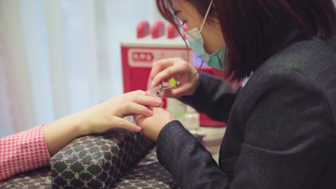 女顾客美甲师女性在美容院做美甲手部特写