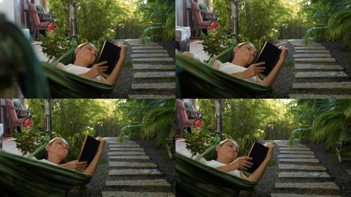 躺在阳台吊床上看书的年轻女子