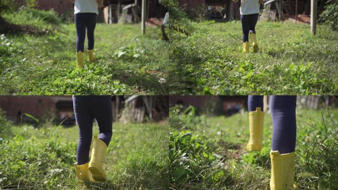 穿着黄色雨靴的女孩在草坪上行走