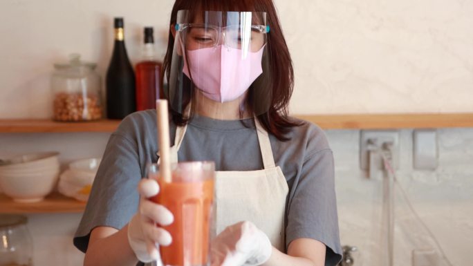 一名亚洲妇女在咖啡馆做新鲜果汁