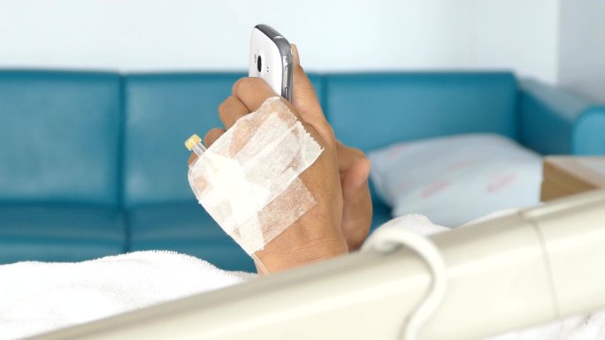 女患者在病床上使用智能手机