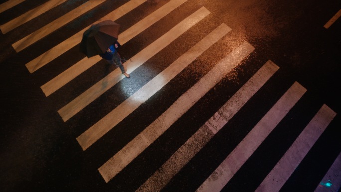 雨天撑伞过人行道的人