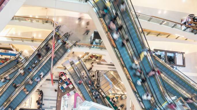 现代购物中心拥挤的使用自动扶梯的人