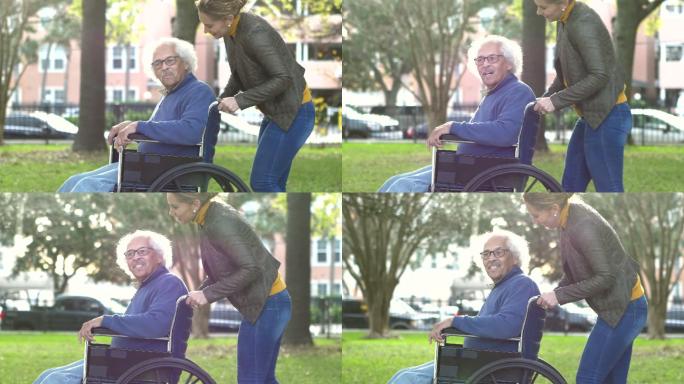 妇女推着轮椅上的年长父亲