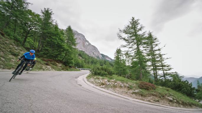 三名公路自行车手在高山公路上超速行驶