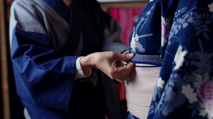 一名日本妇女在游客和服上调整Obi的特写镜头