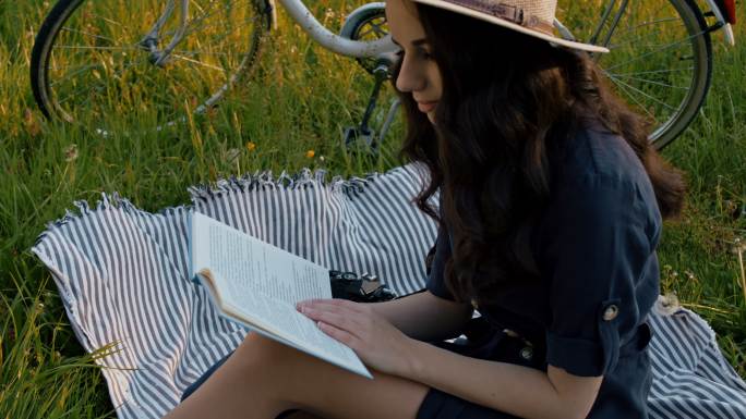 女士年轻女子在野餐毯上看书