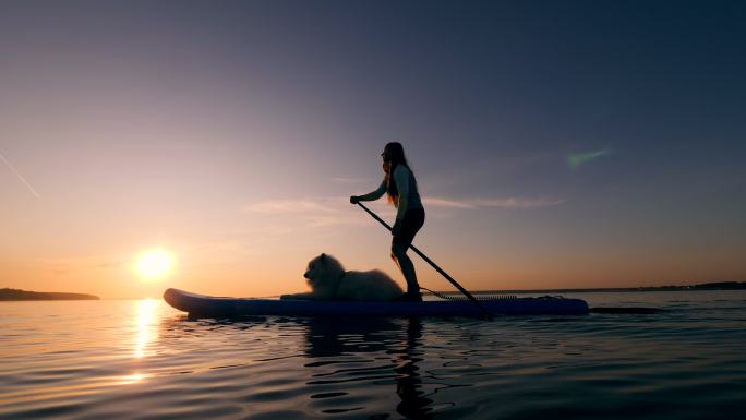 女子和狗狗在湖面划船