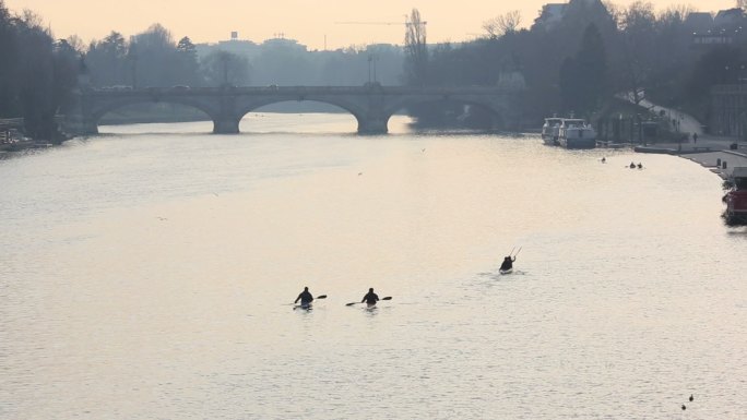 远处的皮划艇运动员沿着河道逆流而上