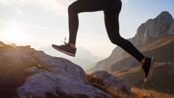 在山地的岩石小径和草坡上跑上坡