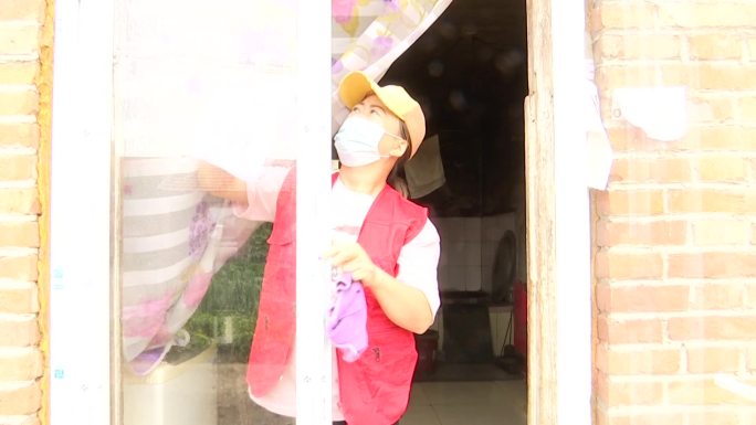 村里的爱心团队志愿者帮助村民搞卫生擦玻璃