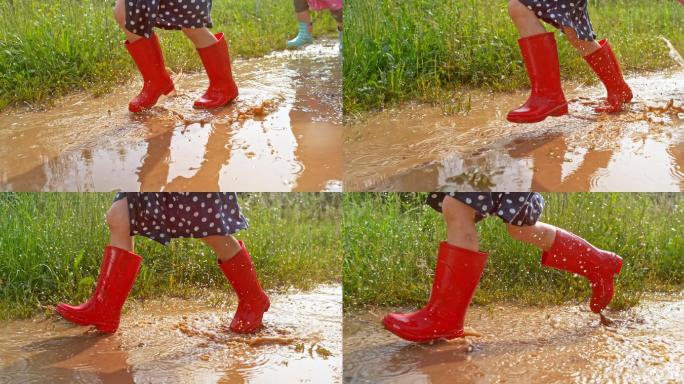 穿着红色雨靴的小女孩跑过泥泞的水坑