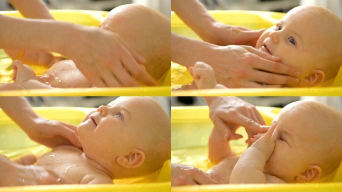 在黄色塑料浴缸中为6个月大的婴儿洗澡