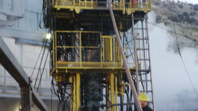 油田工人在金属平台上安装钻杆