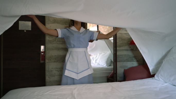 在旅馆铺床的漂亮女佣