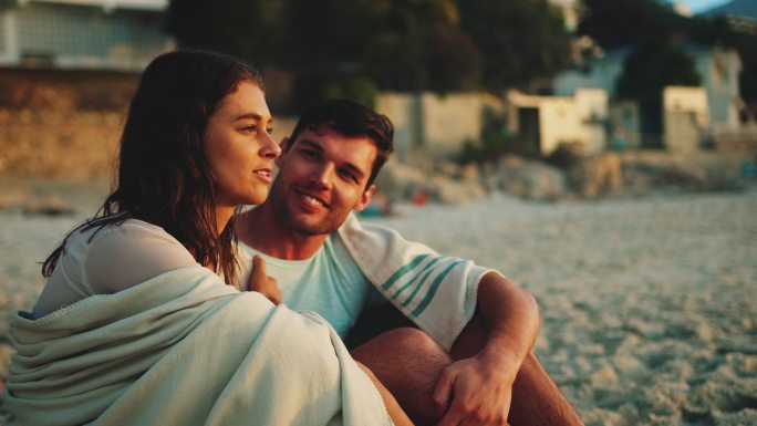 坐在海滩上的夫妇外国情侣夫妻海边看日出聊