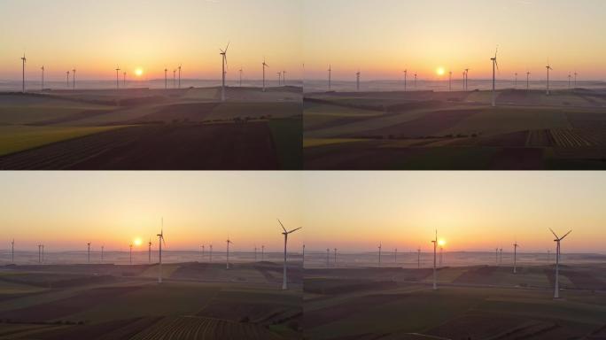 日出时，风力涡轮机在农村耕地间旋转