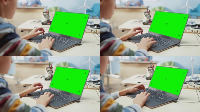 一个孩子使用绿色彩色键屏幕笔记本电脑