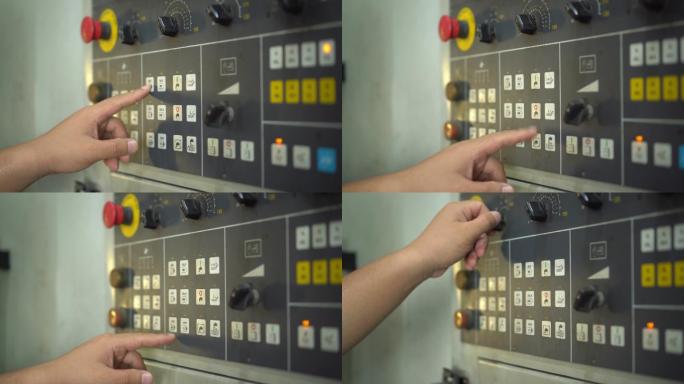 一名工人按下按钮在工厂安装机器的特写镜头。