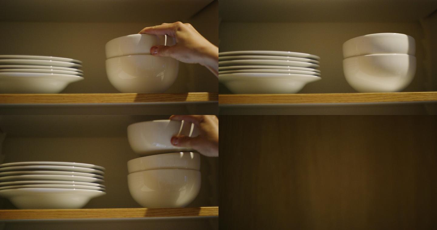 妇女将碗放入一个打开的厨房碗柜