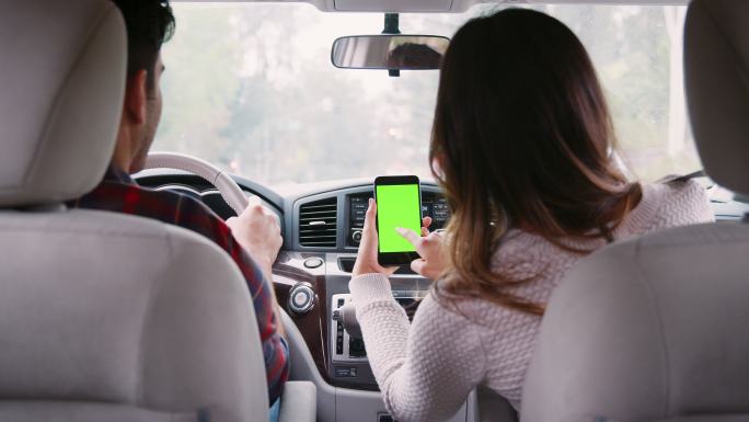 女性乘客在乘车途中使用智能手机上的GPS