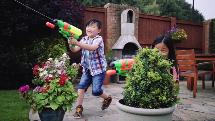 在花园里打水仗小孩子玩耍小学生玩水枪