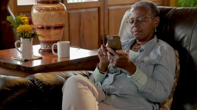 非洲裔美国老年妇女用手机放松