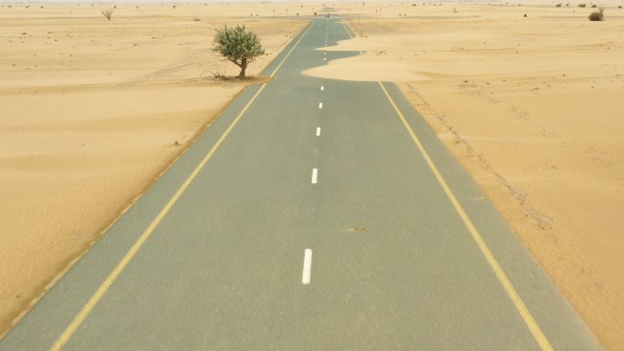 迪拜沙漠中部的沙丘覆盖着一条荒芜的道路