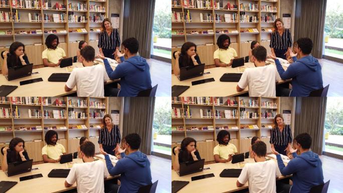 图书馆里学生小组进行研究和交谈