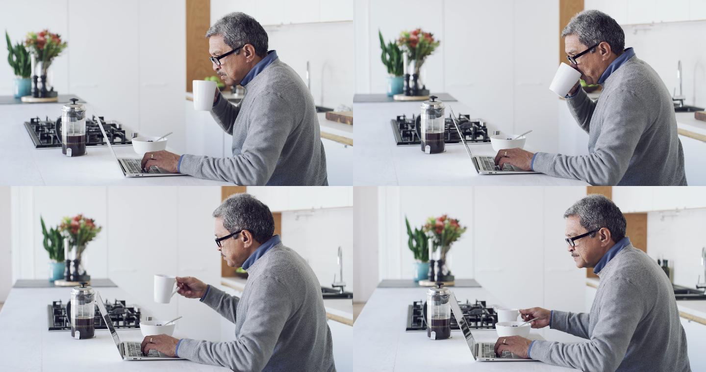 一名老人在家吃早餐时使用笔记本电脑