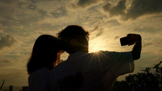 情侣在海上夕阳时自拍