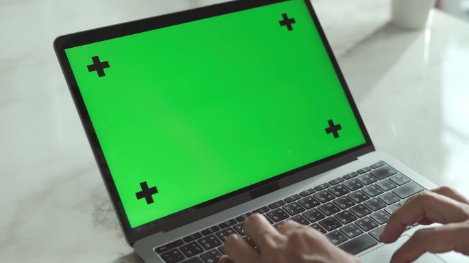 年轻人使用带有绿色屏幕的笔记本电脑