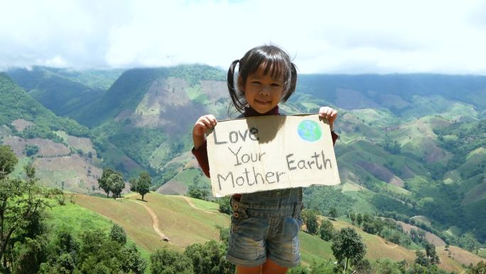 举着“爱你的地球母亲”海报的小女孩