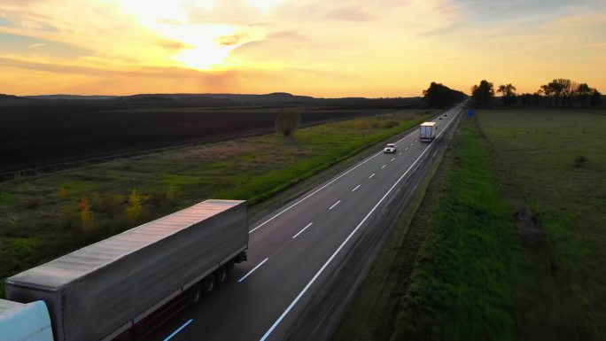 空中无人机视图：半卡车在公路上运送货物时会合。