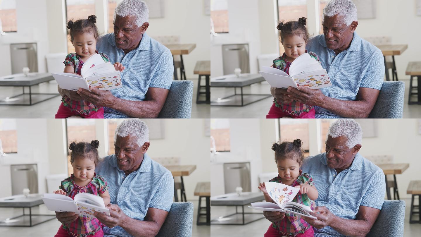 爷爷和小孙女坐在家里的沙发上看书